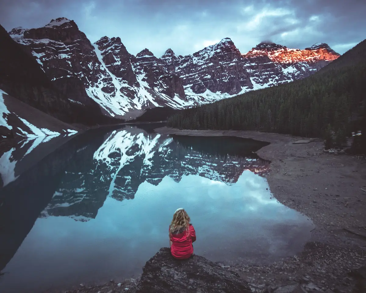 A visitor watching the morning light at Moraine Lake